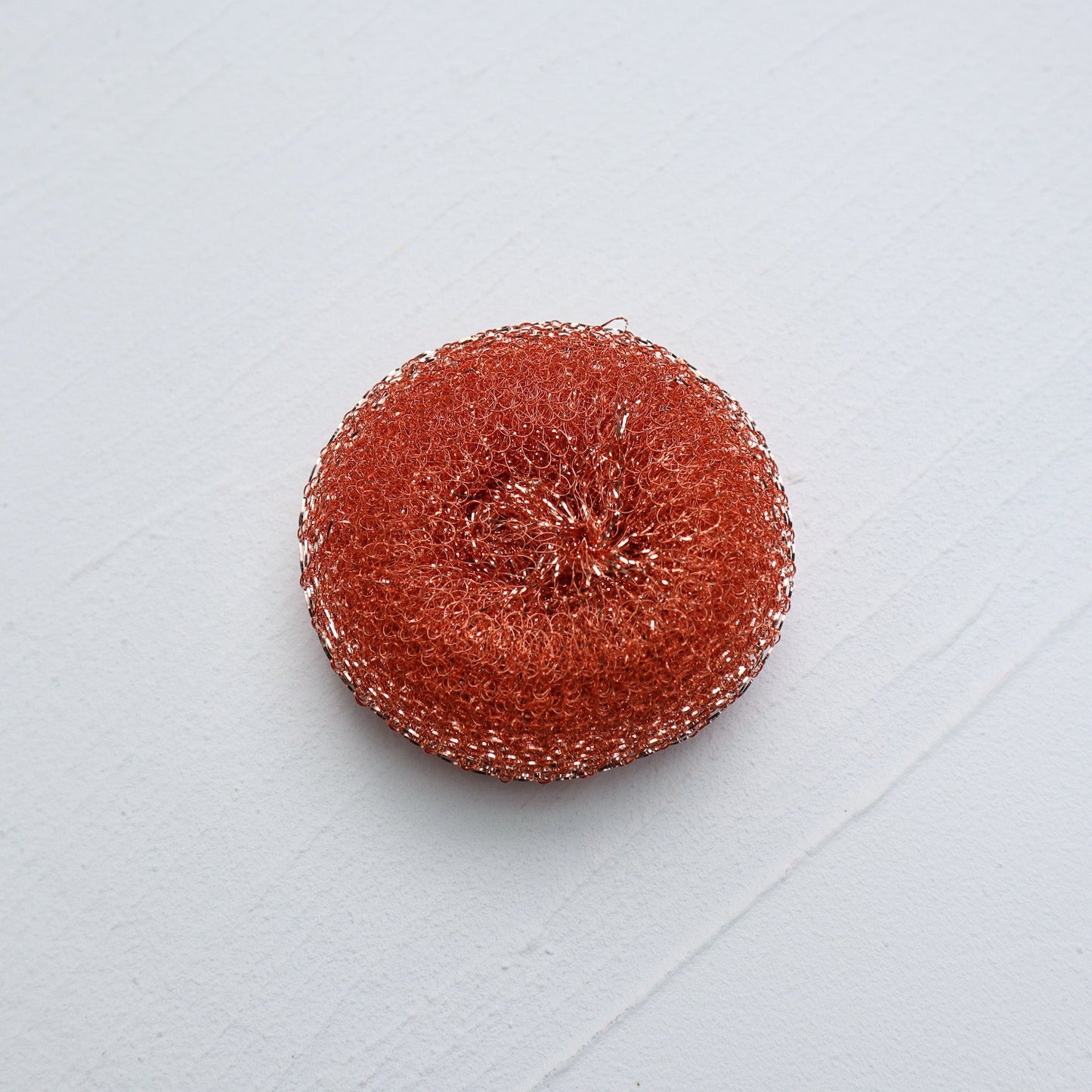 Round red scrubbie on a light gray background