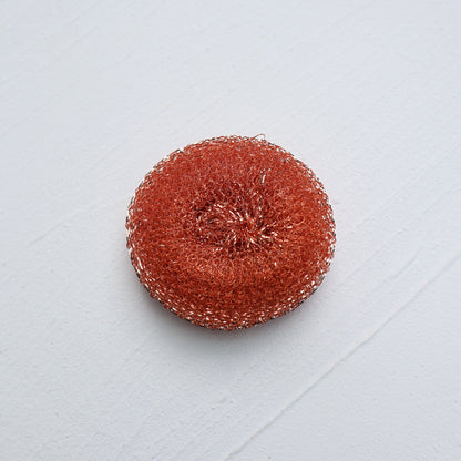 Round red scrubbie on a light gray background