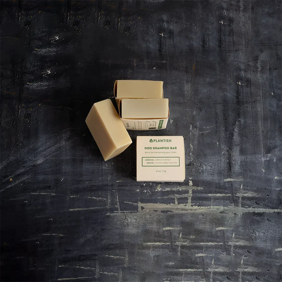 Three dog shampoo bars on a textured black surface with 'Plantish' branding.
